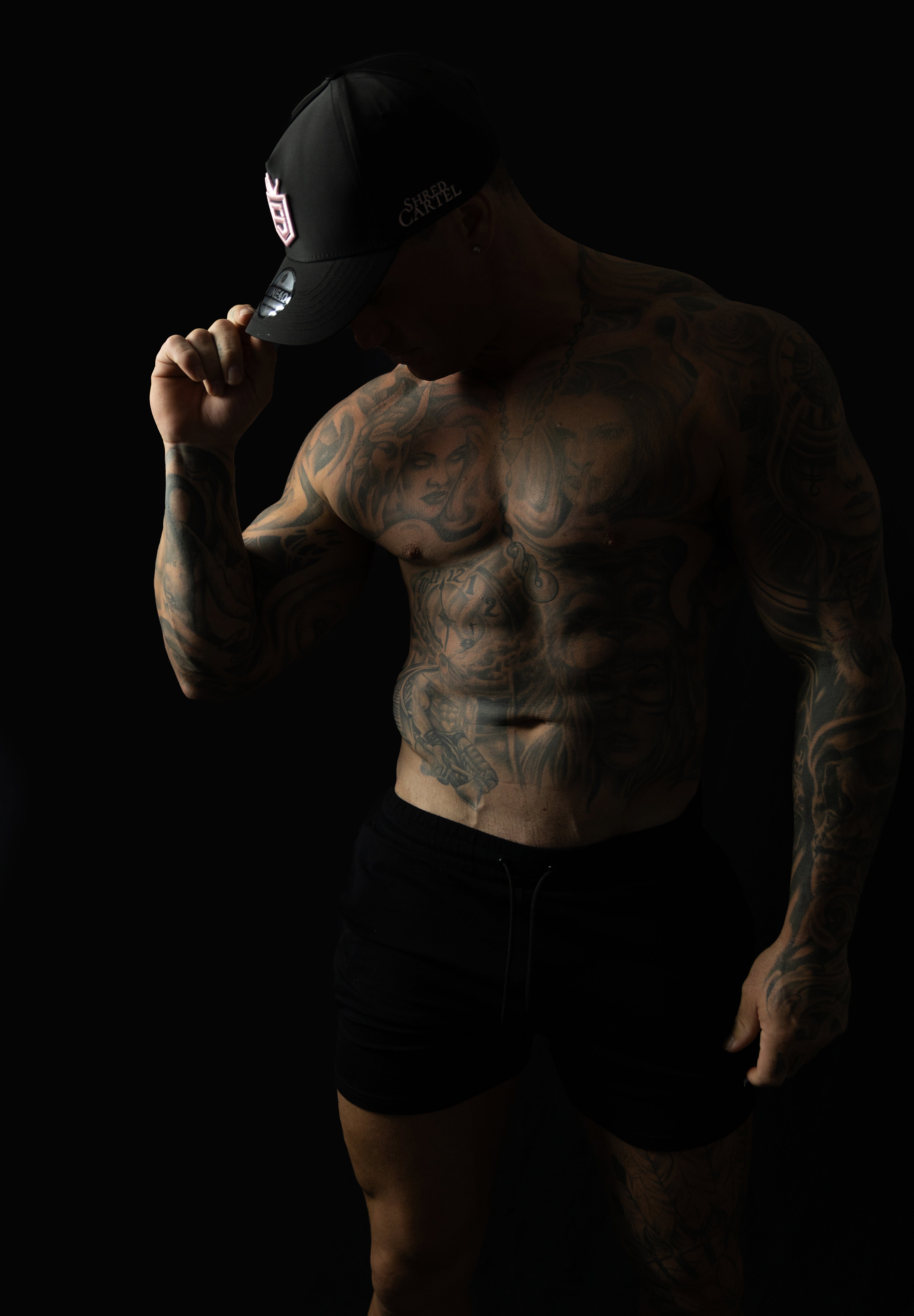 Model wearing black and pink sweat-resistant snapback cap left view – Shred Cartel Elite Series
