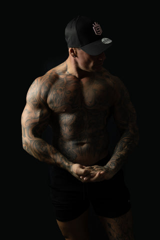 Model wearing black and pink sweat-resistant snapback cap side view – Shred Cartel Elite Series